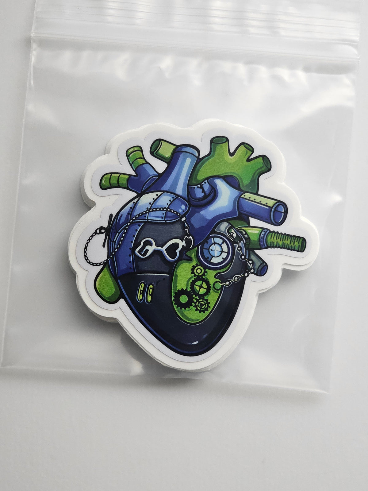 Colorful heart-shaped sticker with mechanical design on a clear background