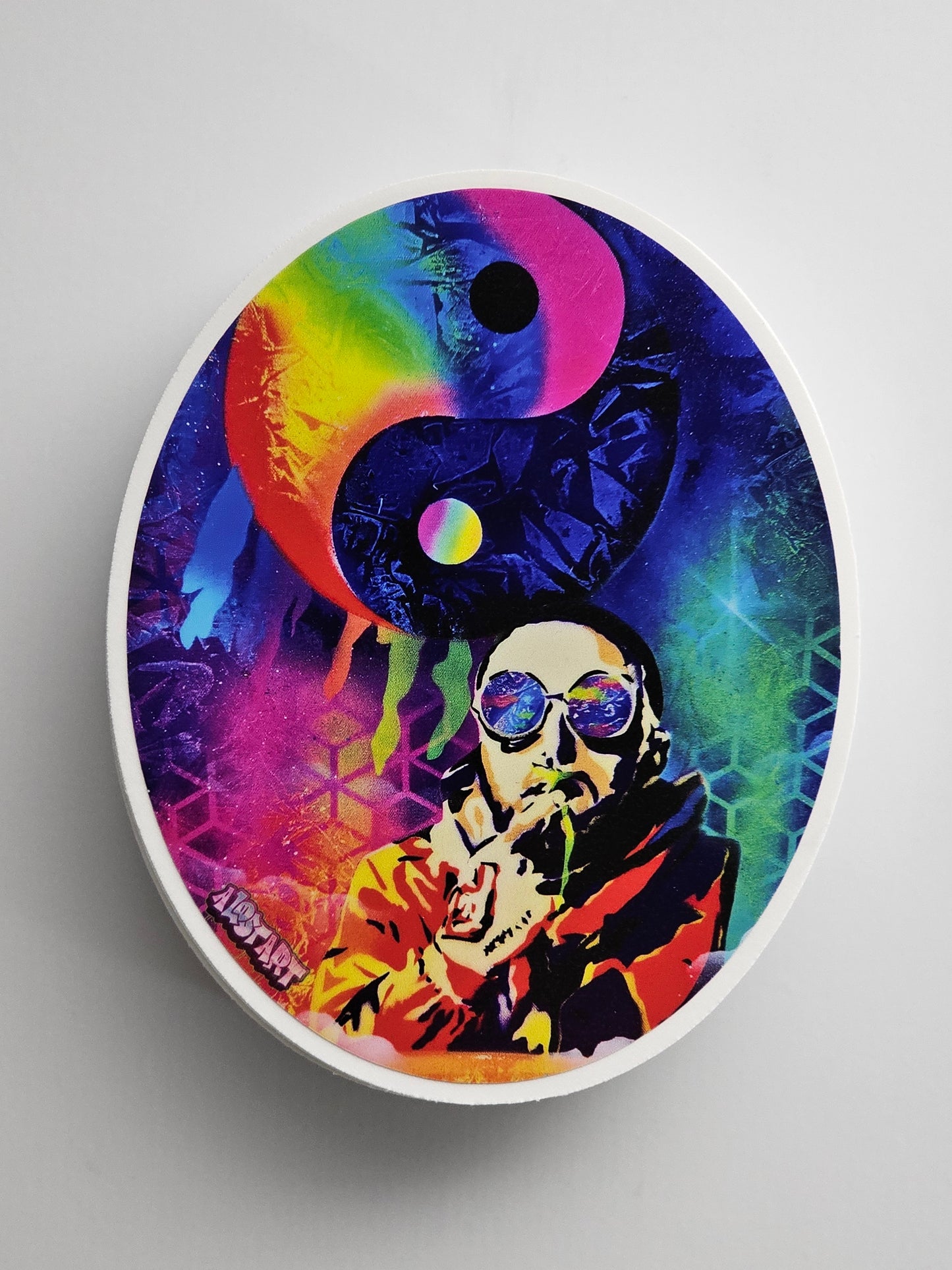 Colorful sticker with a yin yang symbol and artistic design on a gray background