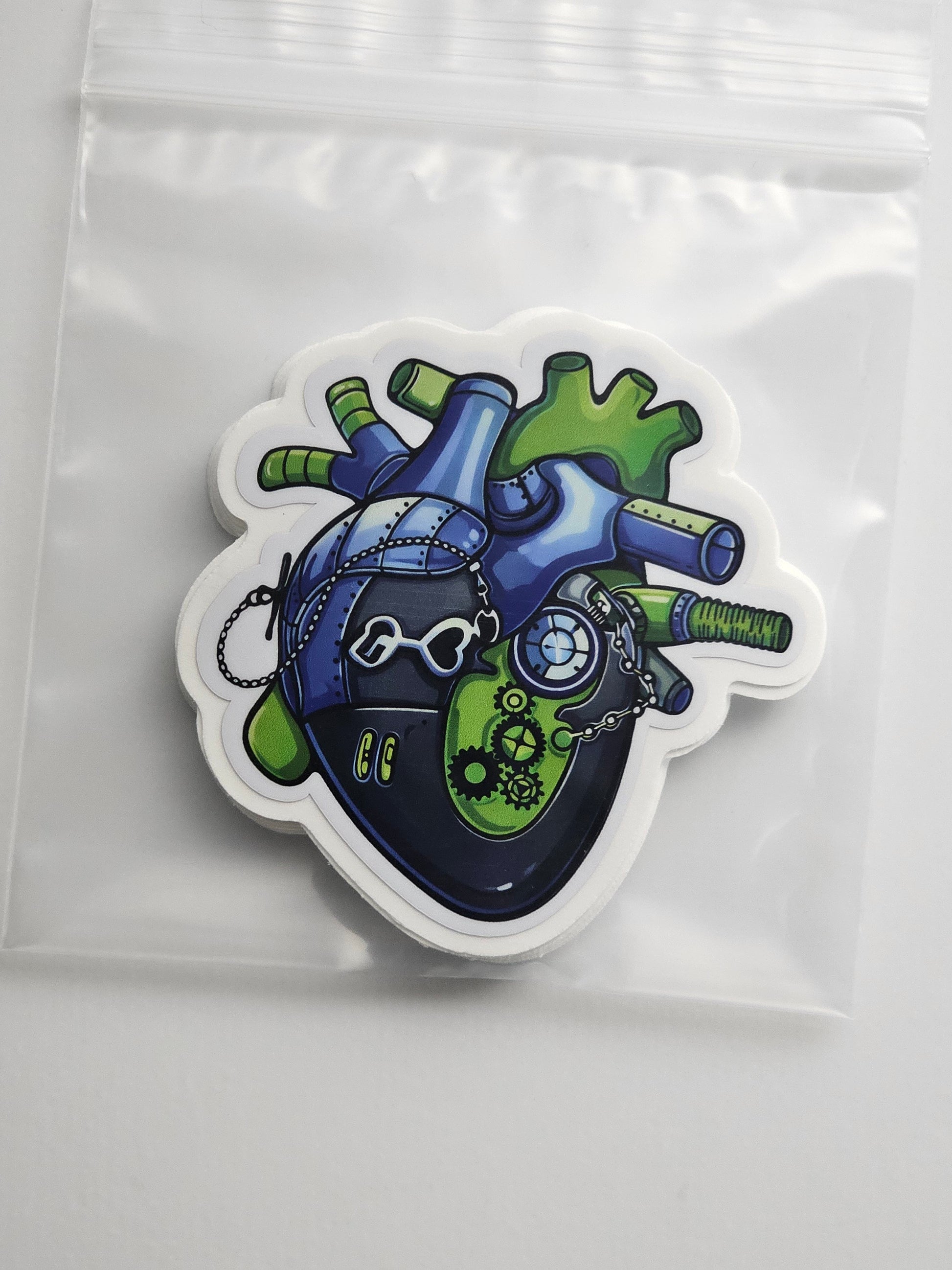 Colorful heart-shaped sticker with mechanical design on a clear background