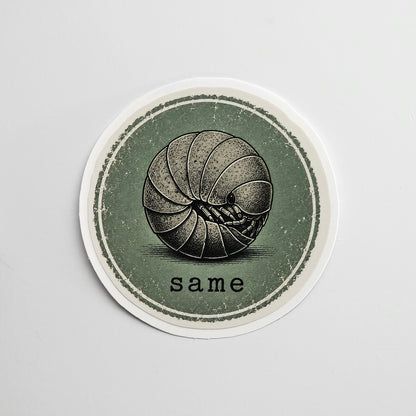 Circular sticker with a black and white roly poly illustration of a ball and the word 'same' on a gray background